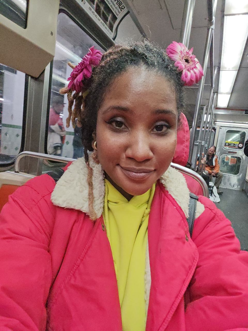 Me on the train home with pink gerbera daisies in my hair